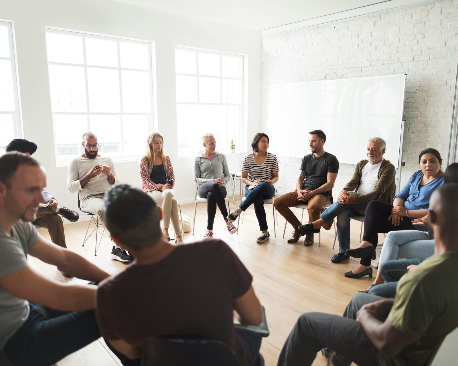 Diverse adults in a group therapy circle in Houston