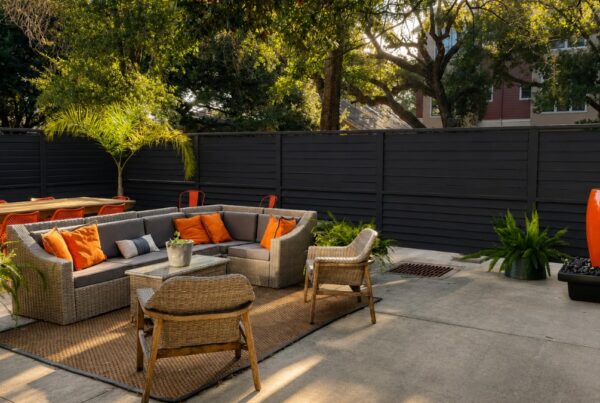 Shaded outdoor patio with lounge seating and orange cushions at Heights Behavioral Health in Houston