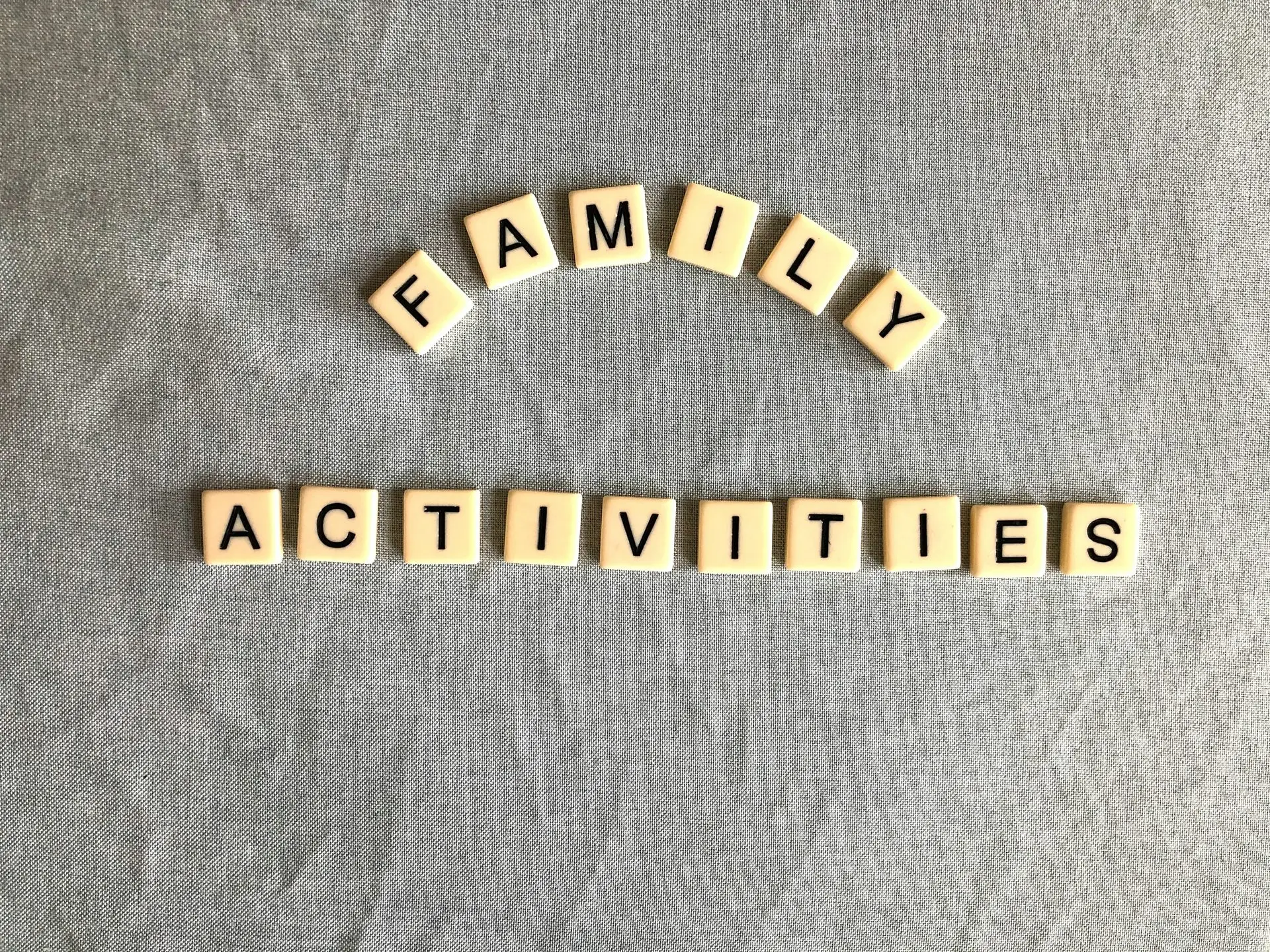 Letter tiles spelling family activities, representing structured family therapy exercises