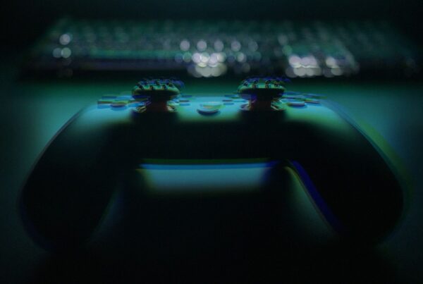 Video game controller and keyboard in low light, representing late night gaming and screen addiction