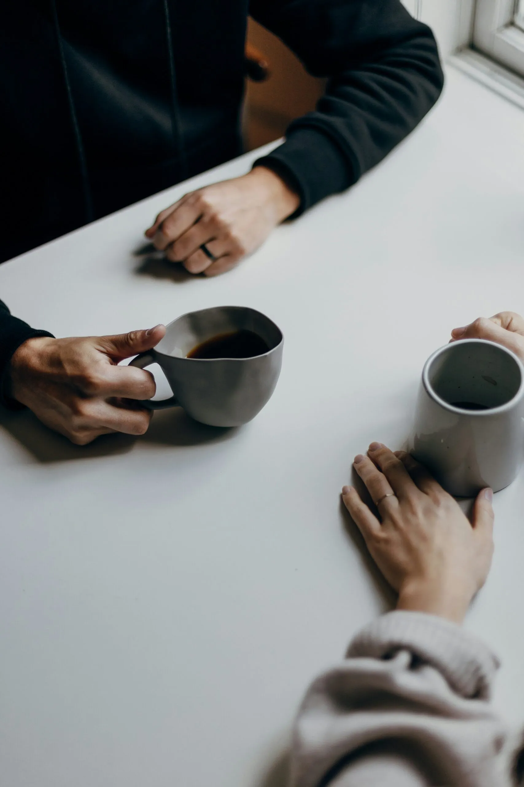 Two people sharing coffee during a supportive one on one conversation, illustrating hemp THC in Texas