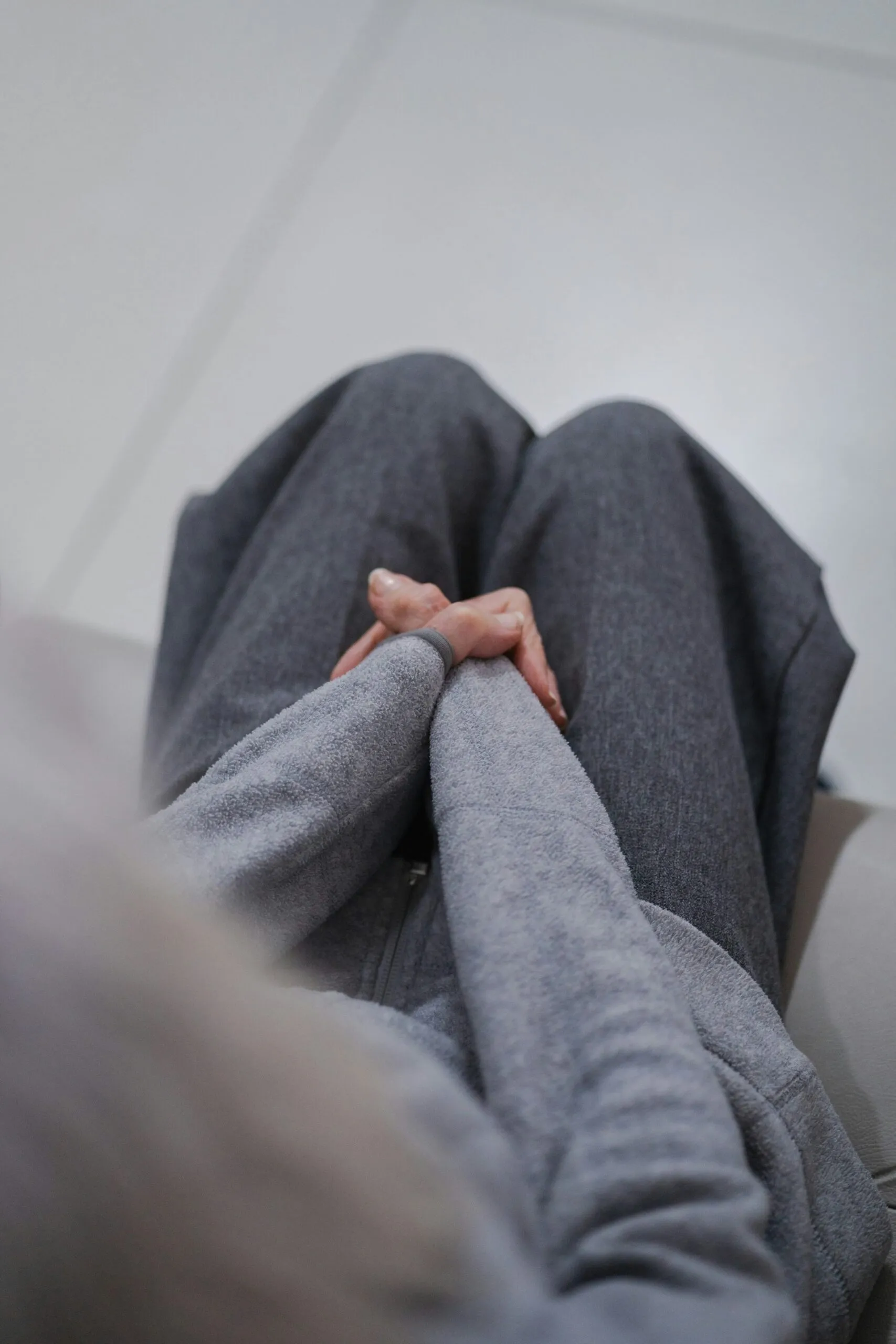 Person with hands clasped on their knees during exposure and response prevention therapy for OCD and anxiety in Houston